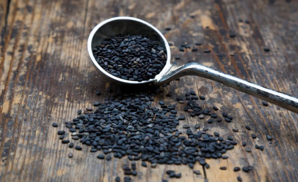 A bowl of black sesame seeds with a focus on their nutritional and health benefits.
