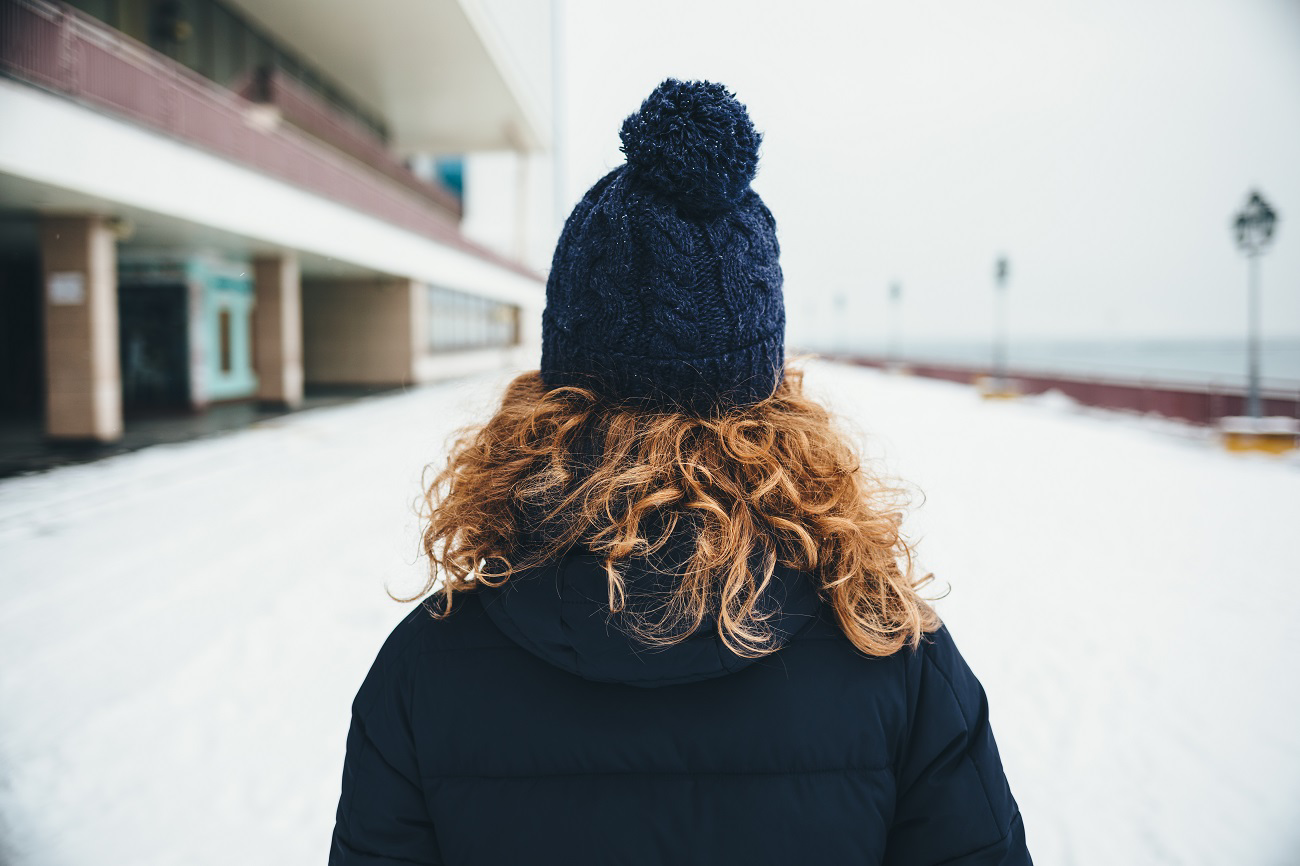 A person enjoying healthy, vibrant hair in a winter setting, embodying the essence of the 13 Top Winter Hair Care Tips For Healthy Locks.